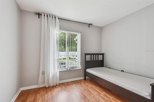 bedroom with baseboards and wood finished floors