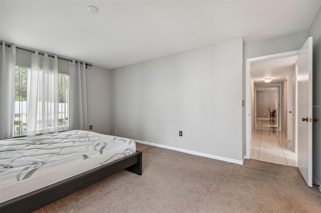 bedroom with carpet, tile patterned flooring, and baseboards