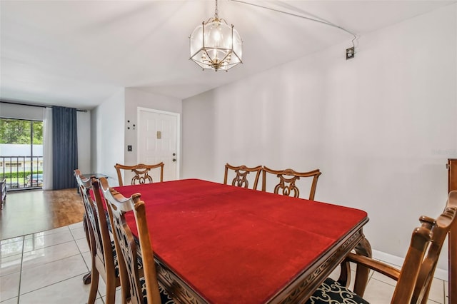 dining space featuring an inviting chandelier, light tile patterned floors, and baseboards