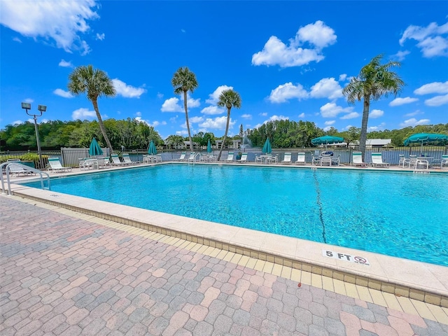 community pool featuring a patio area and fence