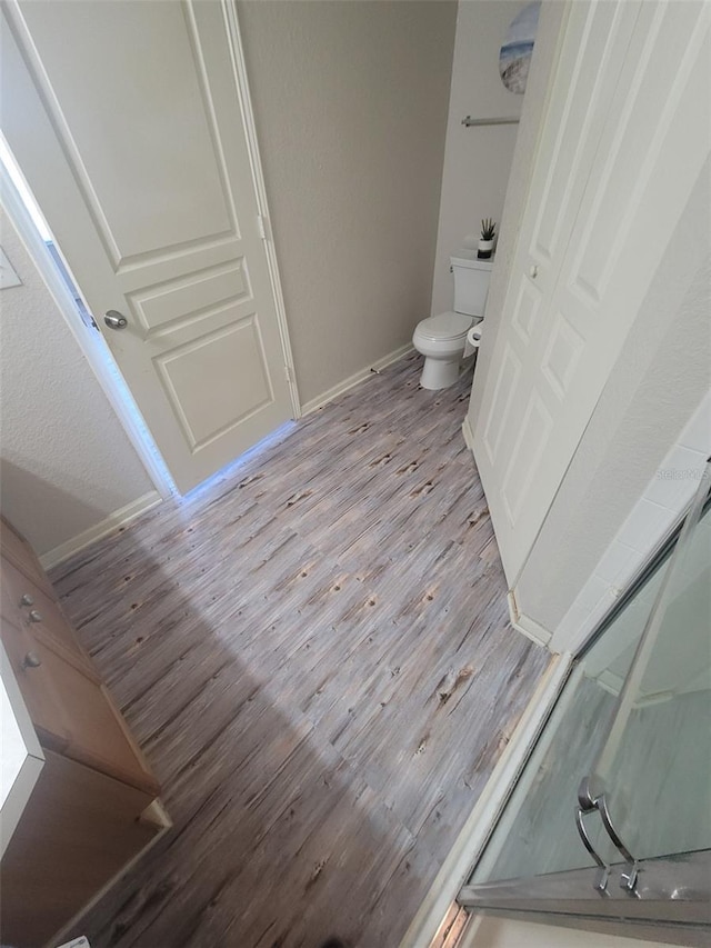 bathroom featuring wood-type flooring and toilet