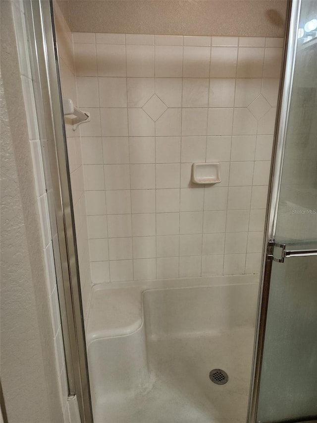 bathroom featuring a shower with door