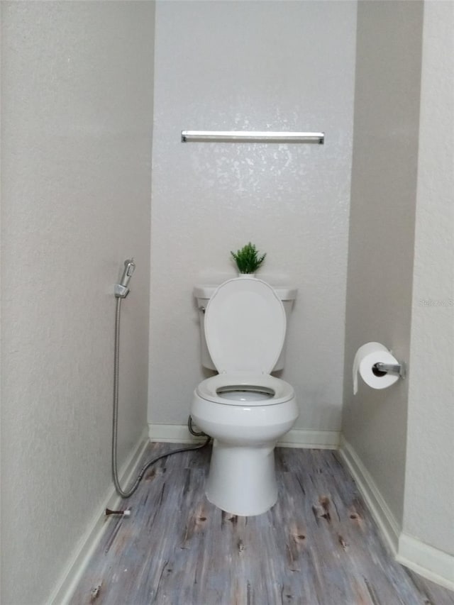 bathroom featuring hardwood / wood-style floors and toilet