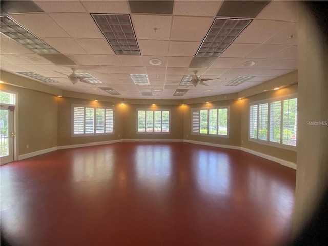 spare room with a paneled ceiling, a wealth of natural light, and ceiling fan