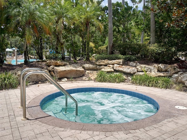 view of swimming pool featuring an in ground hot tub