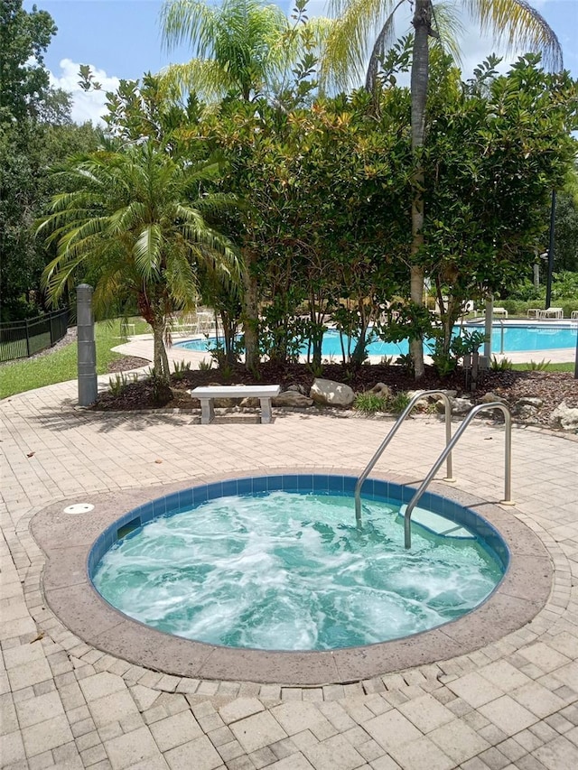 view of pool featuring a community hot tub and a patio area