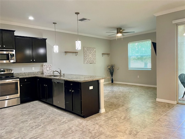 kitchen featuring light stone countertops, decorative light fixtures, stainless steel appliances, sink, and kitchen peninsula