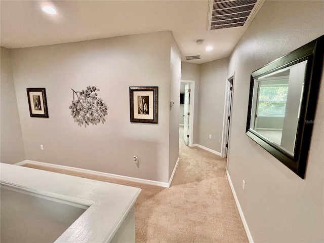 hall with light carpet, baseboards, visible vents, and recessed lighting