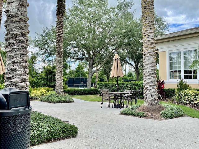 surrounding community featuring a patio and outdoor dining space