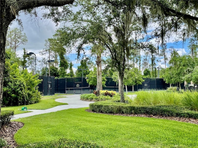 view of property's community with a yard and fence