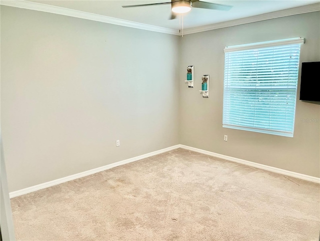 spare room with light carpet, baseboards, ornamental molding, and a ceiling fan