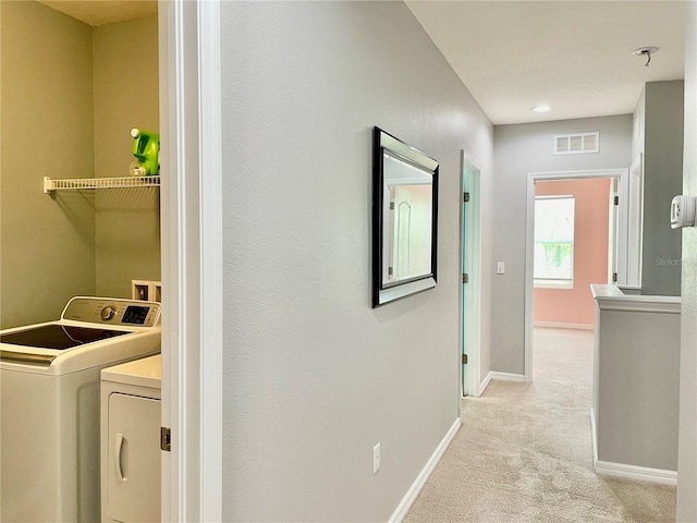 washroom featuring washer and clothes dryer, visible vents, light carpet, laundry area, and baseboards