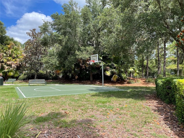 view of sport court with a lawn