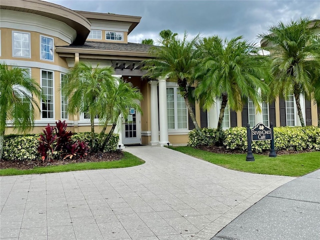 property entrance with roof with shingles and stucco siding