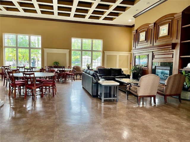 living room featuring a wealth of natural light, a high ceiling, and ornamental molding