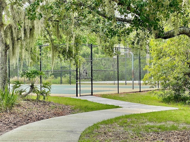 view of sport court featuring a tennis court, a gate, and fence