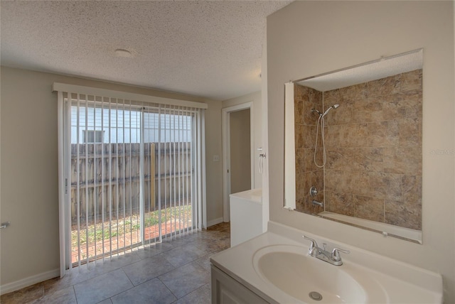 bathroom featuring a textured ceiling, tiled shower / bath combo, vanity, and tile patterned flooring