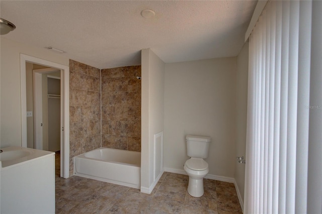 full bathroom with toilet, a textured ceiling, vanity, and tiled shower / bath combo