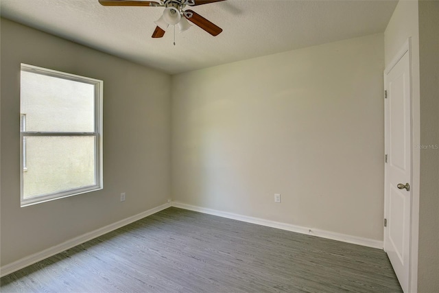 unfurnished room with ceiling fan, a textured ceiling, and dark hardwood / wood-style flooring