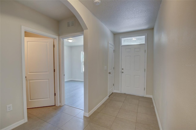 foyer with light tile patterned floors and a textured ceiling