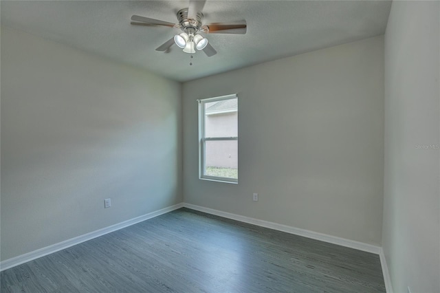 empty room with ceiling fan and dark hardwood / wood-style flooring