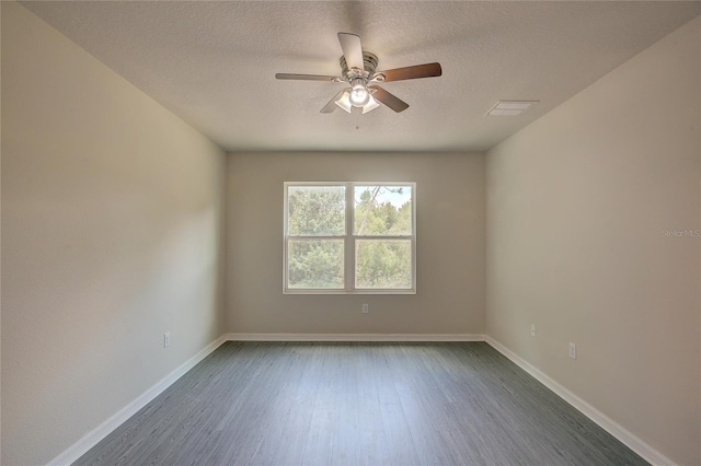 empty room with ceiling fan, dark wood-type flooring, and a textured ceiling