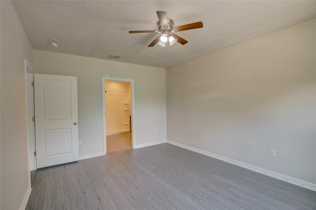 empty room featuring ceiling fan, a textured ceiling, and hardwood / wood-style floors