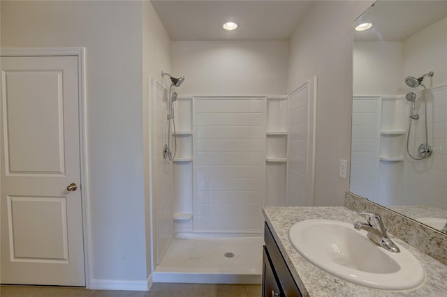 bathroom with tile patterned flooring, walk in shower, and vanity