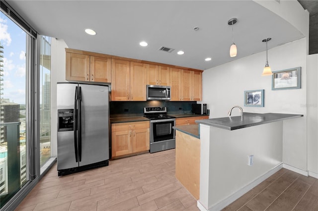 kitchen featuring tasteful backsplash, hanging light fixtures, stainless steel appliances, and a healthy amount of sunlight