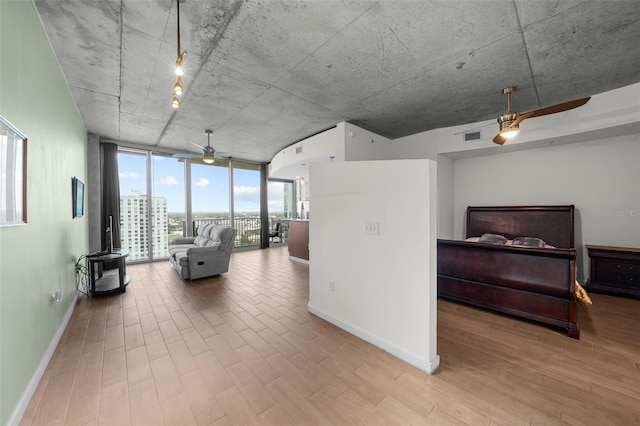 living room featuring light hardwood / wood-style floors, expansive windows, and ceiling fan