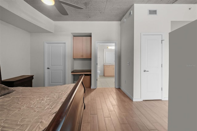 bedroom featuring connected bathroom, ceiling fan, and light wood-type flooring