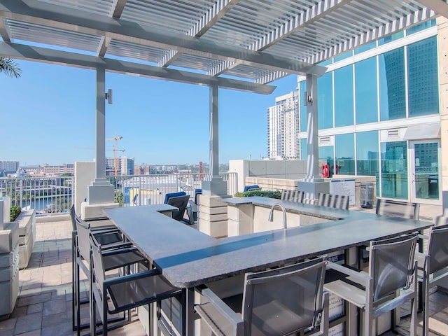 view of patio with a water view, an outdoor bar, and a pergola