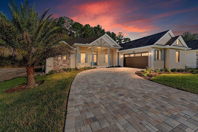 view of front of house featuring a garage and a lawn