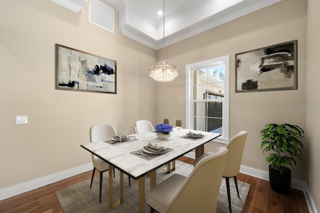 dining room featuring dark hardwood / wood-style flooring, an inviting chandelier, and ornamental molding