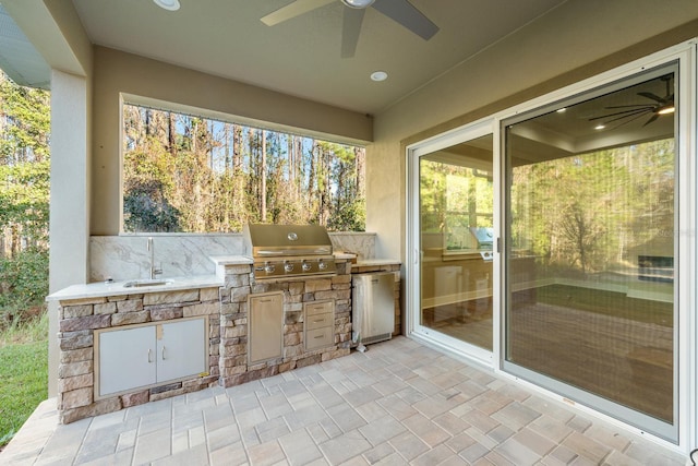 view of patio / terrace with ceiling fan, an outdoor kitchen, grilling area, and sink