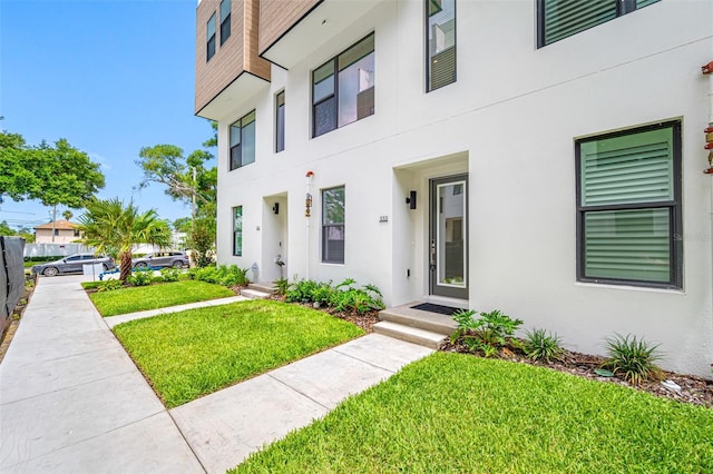 doorway to property featuring a lawn