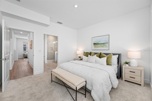 bedroom with light carpet and ensuite bath