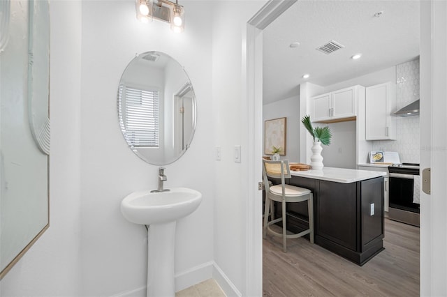 bathroom with backsplash and hardwood / wood-style flooring