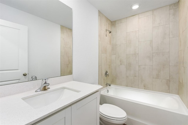 full bathroom with vanity, tiled shower / bath combo, and toilet