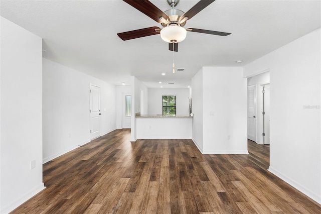 unfurnished living room featuring dark hardwood / wood-style floors and ceiling fan