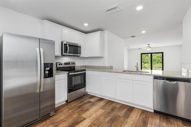 kitchen with white cabinets, stainless steel appliances, kitchen peninsula, and sink