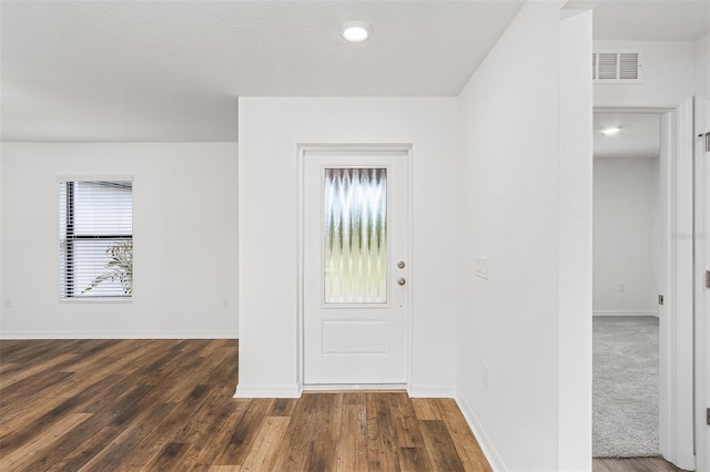 entryway featuring a healthy amount of sunlight and dark carpet