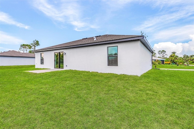 back of house featuring a patio and a yard