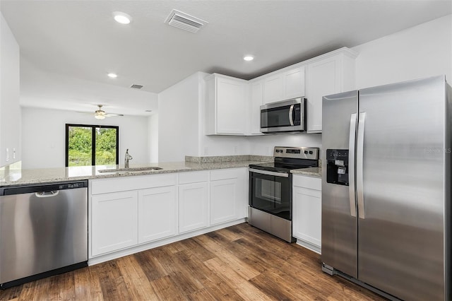 kitchen featuring white cabinetry, sink, kitchen peninsula, stainless steel appliances, and light stone countertops