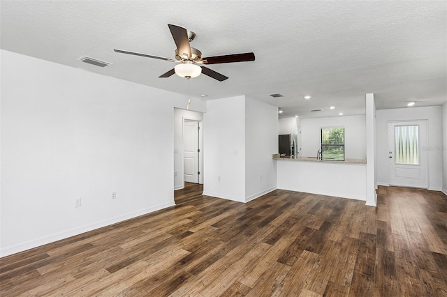 unfurnished living room with ceiling fan, dark hardwood / wood-style flooring, sink, and a textured ceiling