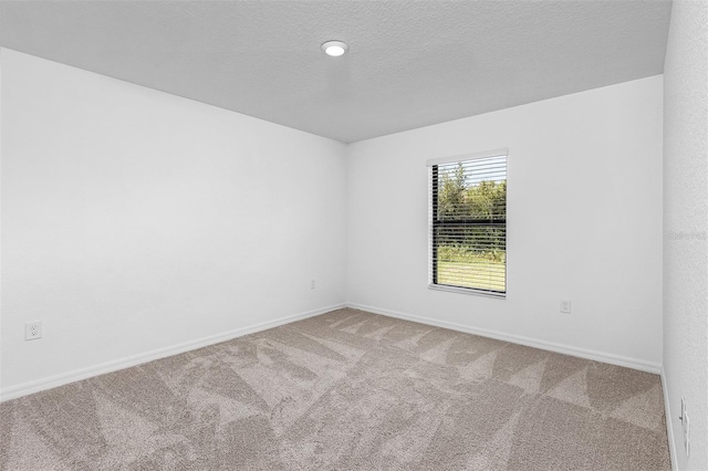 carpeted spare room featuring a textured ceiling