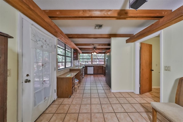 kitchen featuring beamed ceiling, appliances with stainless steel finishes, and light tile patterned floors