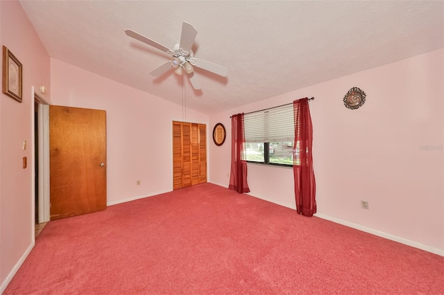 unfurnished bedroom featuring lofted ceiling, carpet floors, ceiling fan, and a closet