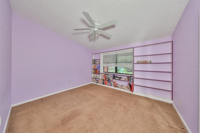 empty room featuring carpet, ceiling fan, and built in shelves