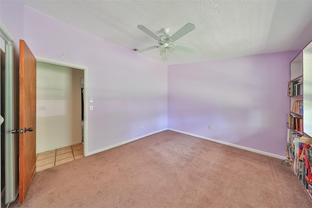 spare room with ceiling fan, carpet, and a textured ceiling